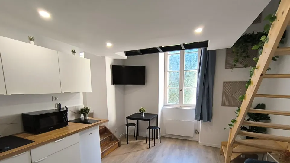 Cuisine équipée et séjour d’un appartement meublé rénové par L’Investisseur Immo